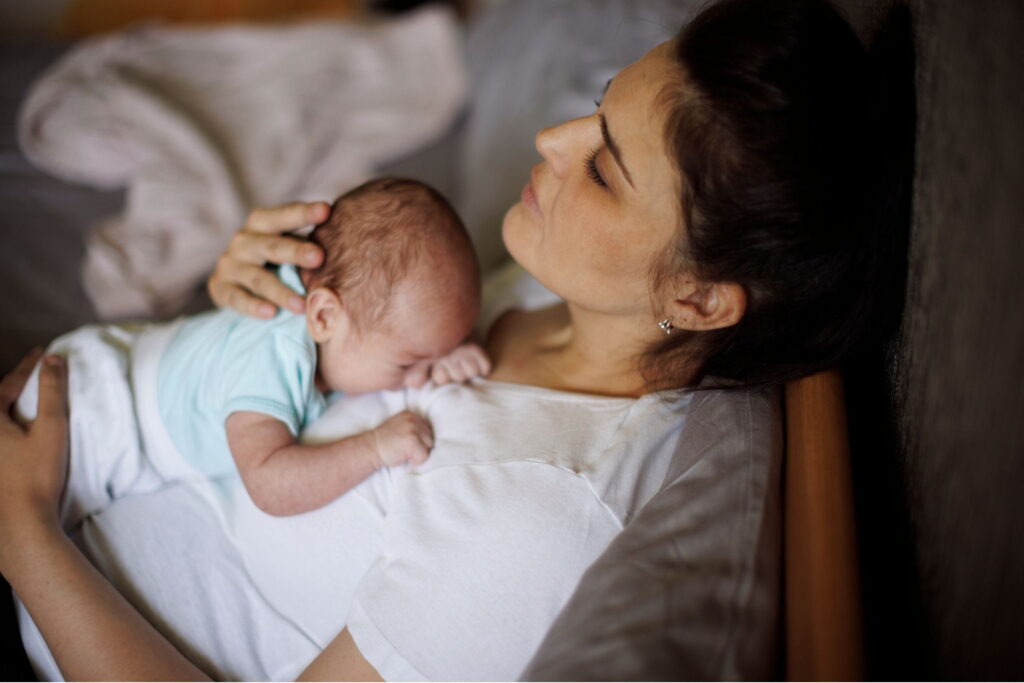 new mother with postpartum depression holding her baby