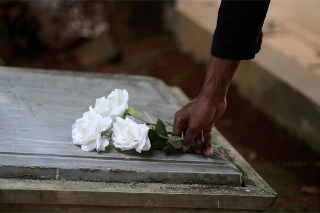 person laying flowers on grave coping with grief and loss