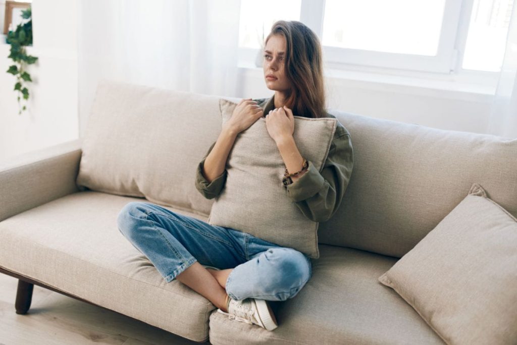 woman with an anxiety disorder sits alone on her couch